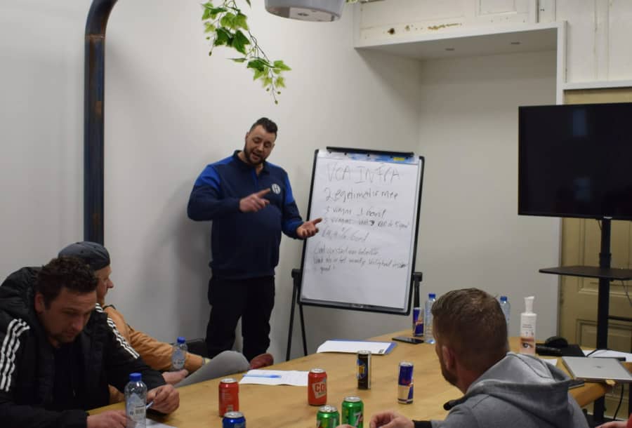Welmer geeft klassikaal les bij een whiteboard aan een groep cursisten